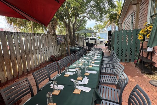 Garden Street Bistro’s brick courtyard with string lights, a red awning and long tables